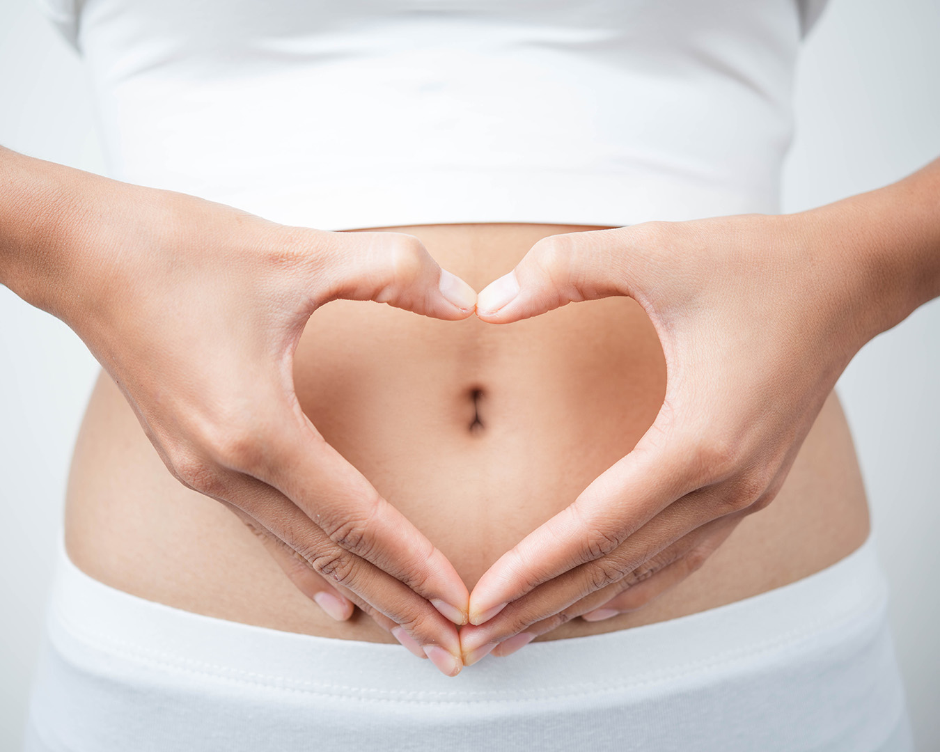 Close,Up,Of,Woman’s,Hands,Made,Heart,On,Belly,Isolated