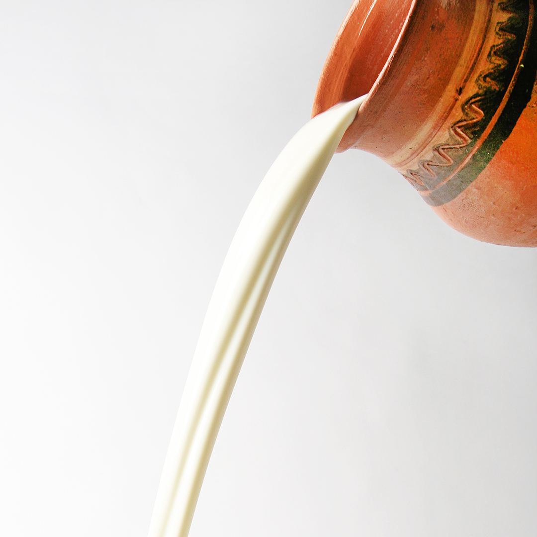 Milk,Pouring,From,Rustic,Jar